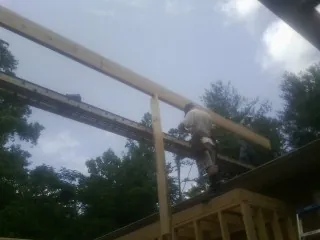 Carpenter setting a ridge beam over a new addition frame — Ice Dam Removal by Roofing Brothers in Griffithsville