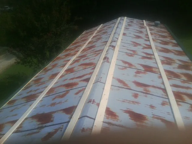 Rusted metal roof panels with new wood purlins before replacement — Storm Damage Roof Repair in Griffithsville by Roofing Brothers