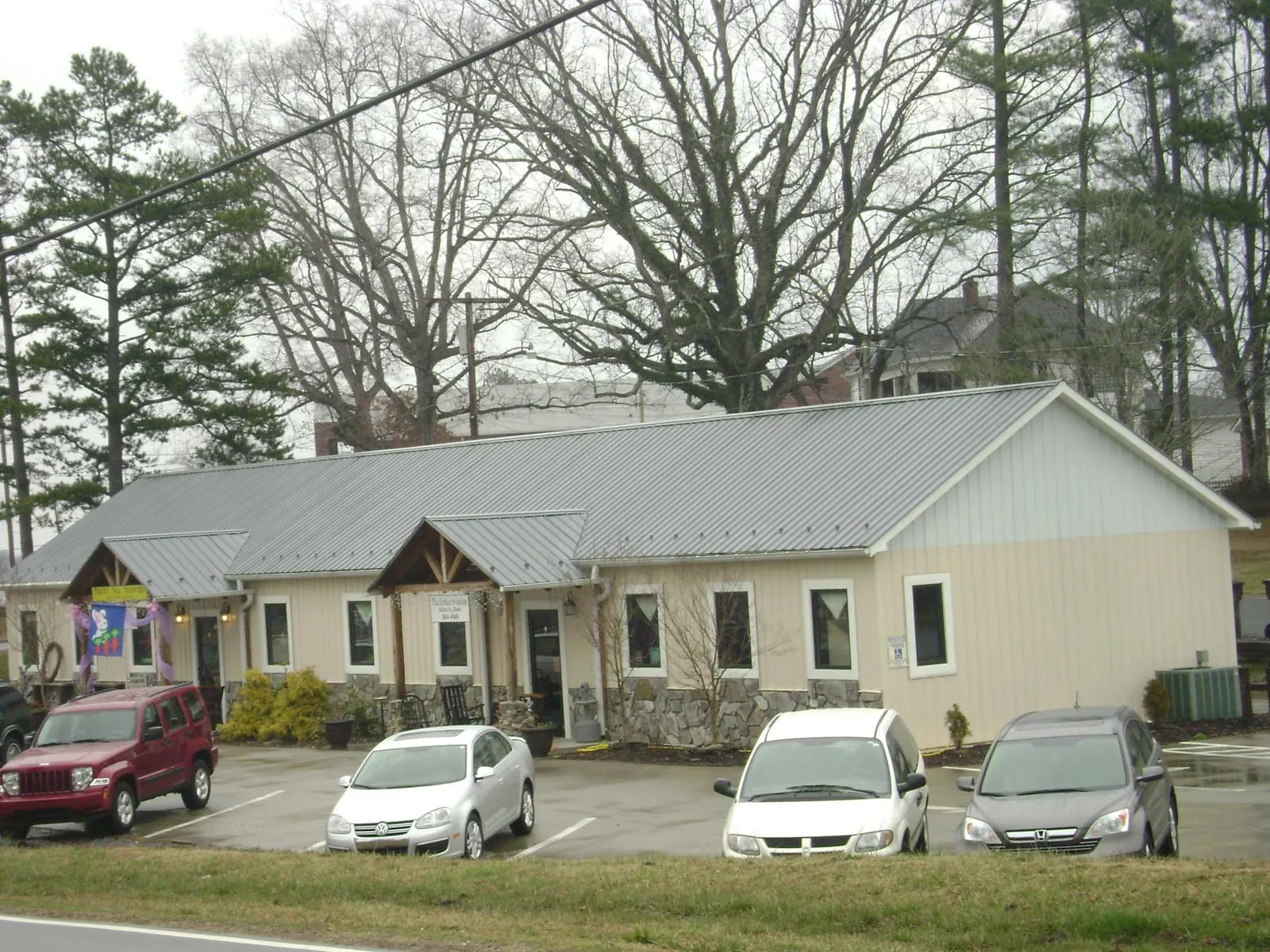 Gray metal roof with timber entry brackets on a small commercial building in Griffithsville
