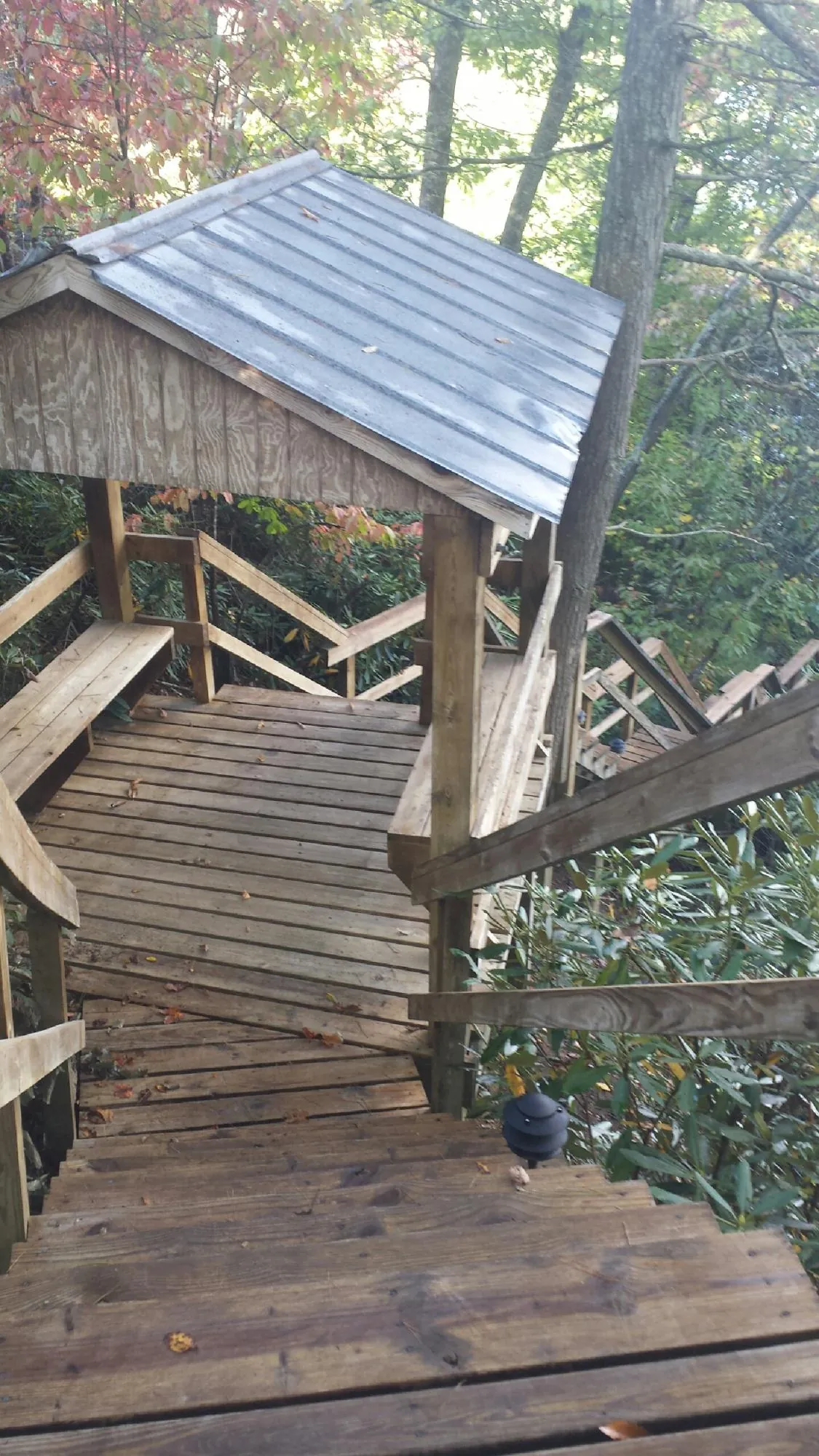 Metal roofed shelter over wooden steps on a wooded walkway — Skylight Repair & Installation work by our crew in Griffithsville
