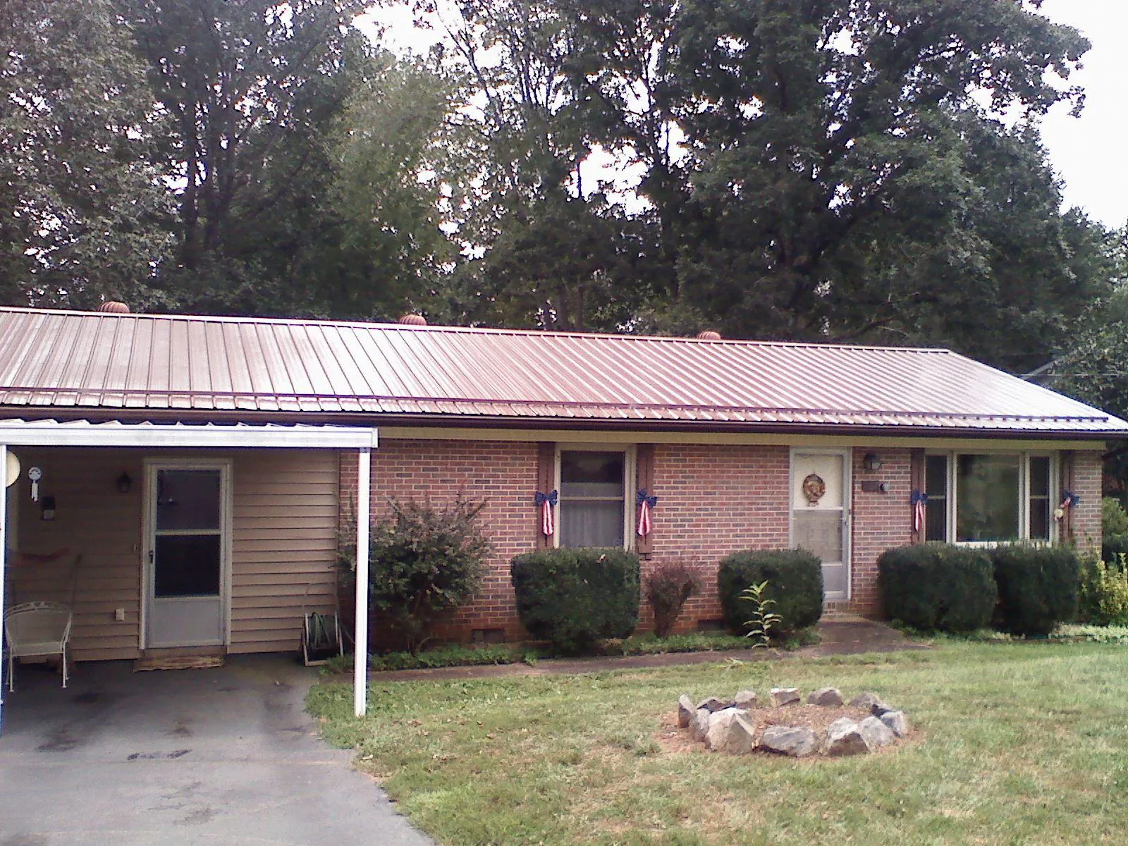 Bronze metal roof and carport on a brick ranch home — Roof Repair work by our crew in Griffithsville